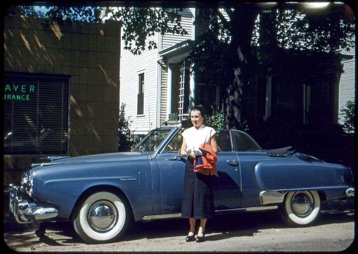 lady standing outside blue car