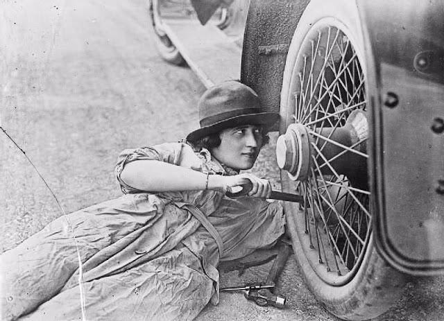 Women auto mechanic working on tire 3