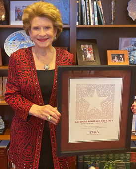 Senator Debbie Stabenow poses with an ANHA Award for championing the passage of the National Heritage Act photo